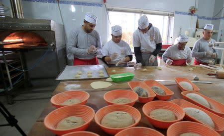Ali Kerdi (L), 35, trains special needs students at a bakery in the southern city of Tyre, Lebanon December 18, 2018. Picture taken December 18, 2018. REUTERS/Ali Hashisho