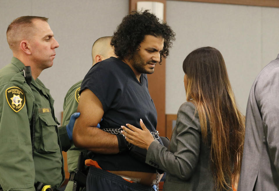Mohamed Abdalla Mahmoud, center, speaks with deputy public defender Zohra Bakhtary in court Tuesday, Aug. 21, 2018, in Las Vegas. Mahmoud was wounded by police after allegedly opening fire with a handgun in a Las Vegas clothing store. (AP Photo/John Locher)