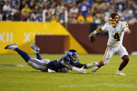 Washington Football Team quarterback Taylor Heinicke (4) scrambles away from New York Giants defensive end Leonard Williams (99) during the second half of an NFL football game, Thursday, Sept. 16, 2021, in Landover, Md. (AP Photo/Patrick Semansky)