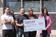 Michigan Lottery Commissioner Suzanna Shkreli, right, and Food Castle owner Nabil Nannoshi, third from left, and his family hold an enlarged check for selling the winning ticket for the $842.4 million Powerball jackpot, from the Jan. 1, 2024 drawing, at Food Castle in Grand Blanc Township, Mich., Tuesday, June 11, 2024. (AP Photo/Paul Sancya)