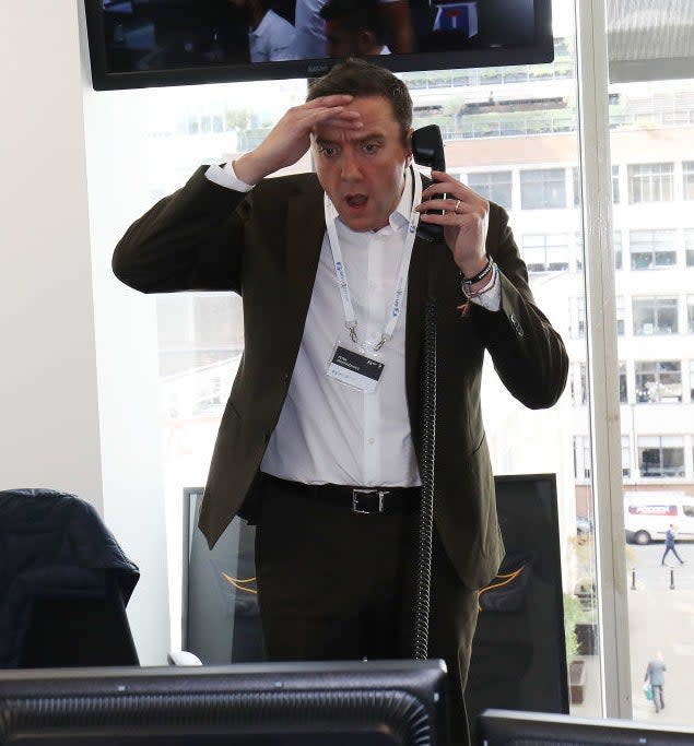 Peter Serafinowicz holding a phone and looking shocked.