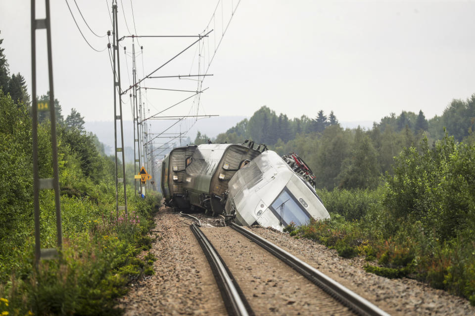 A passenger train carrying 120 passengers derailed between Iggesund and Hudiksvall in Sweden, Monday Aug. 7, 2023. Three people had been taken to hospital in Sweden when two of a train's passenger cars went off the tracks in Hudiksvall, north of Stockholm, police said. The derailment happened because ”the embankment has been undermined by the heavy rain and landslides,“ they said, adding that the extent of their injuries is unclear. (Mats Andersson/TT News Agency via AP)