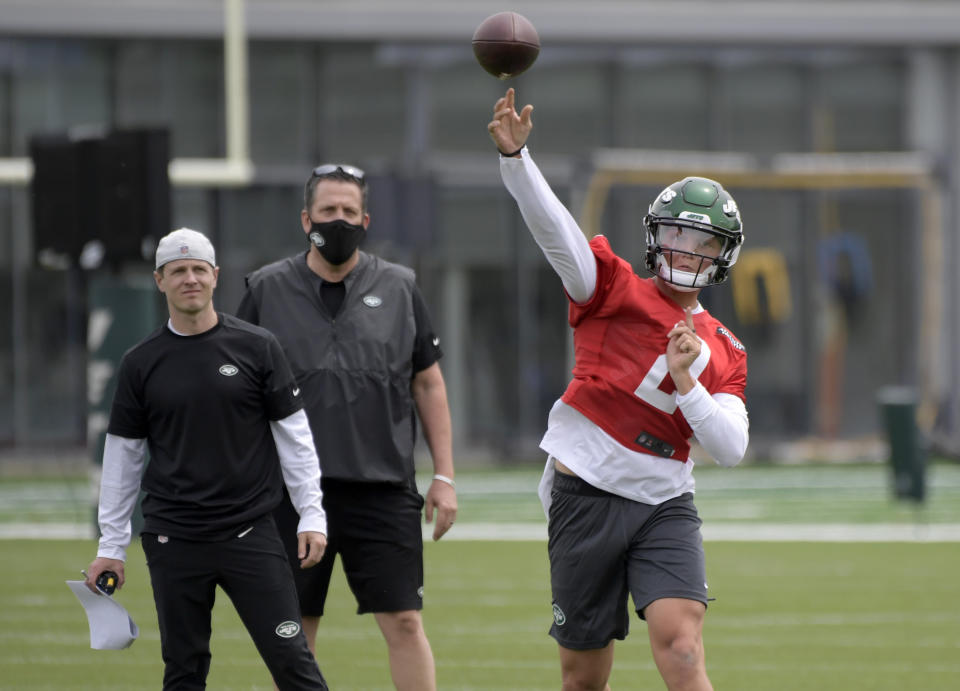 CORRECTS TO OFFENSIVE COORDINATOR MIKE LAFLEUR, LEFT, NOT QUARTERBACKS COACH ROB CALABRESE - New York Jets first-round draft pick Zach Wilson (2) works out as offensive coordinator Mike Lafleur, left, and passing game specialist Greg Knapp, center, look on during NFL football rookie camp, Friday, May 7, 2021, in Florham Park, N.J. (AP Photo/Bill Kostroun)