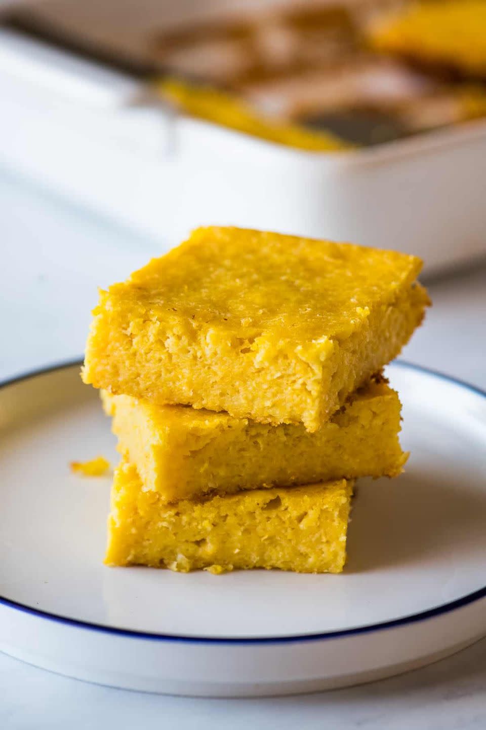 a stack of slices of pan de elote on a white plate