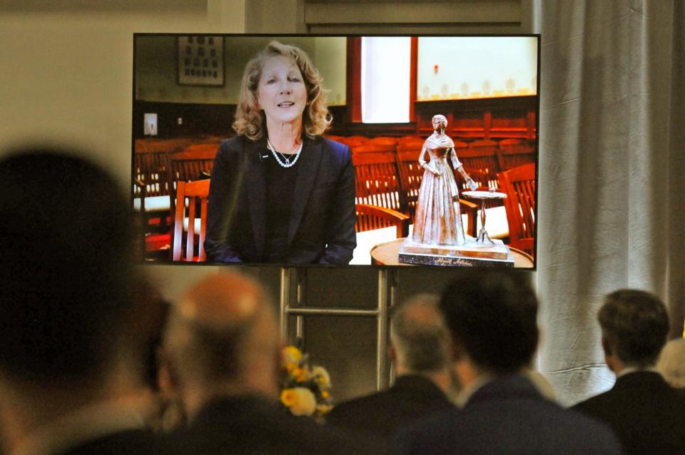 Lauren Baker, wife of former Governor Charlie Baker, addresses the gathering on a video screen about the Adams Presidential Center during the Adams Presidential Center fundraiser gala at Granite Links in Quincy, Tuesday, April 11, 2023.