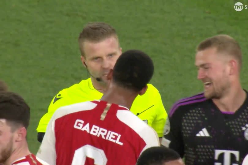 Referee Glenn Nyberg speaks to the Arsenal players