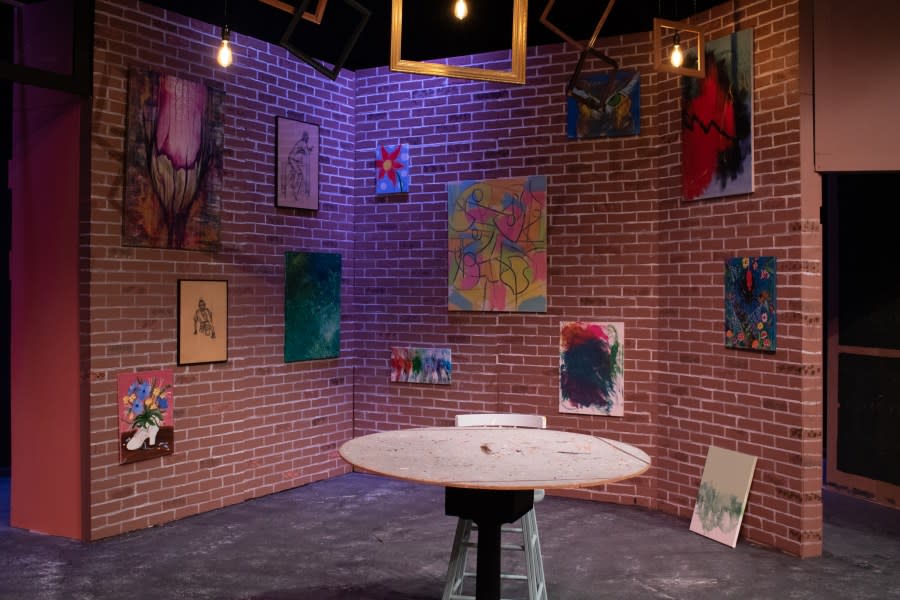 The set was designed and built by Madelyn Dorta and Kathy Graham (plus Daniel Schaummann, Kendall & Kathie Burnett, and Gabe Thompson), featuring paintings by Quad Cities artists.