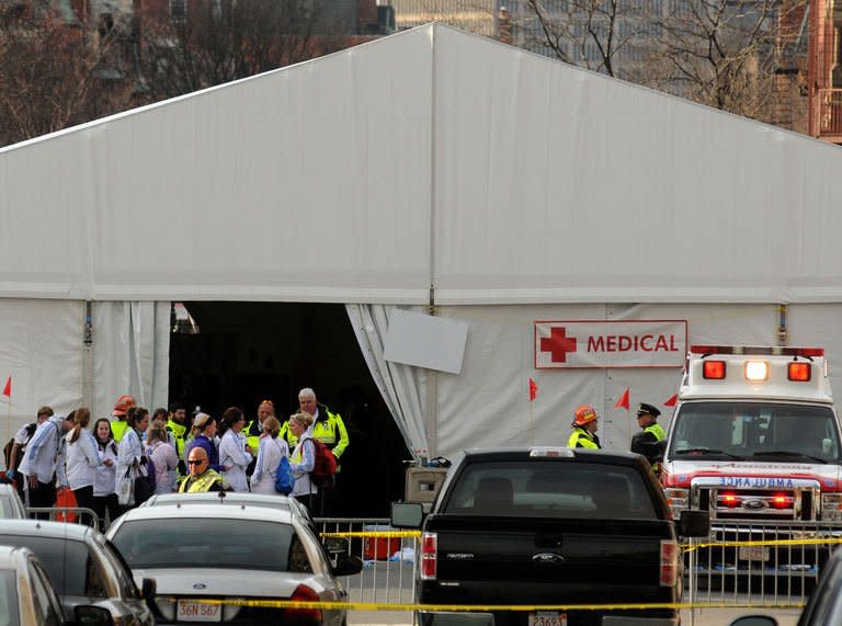 Staff stand outside a medical tent near the finish line of the Boston Marathon where twin explosions killed at least three people and injured more than 100 on April 15, 2013