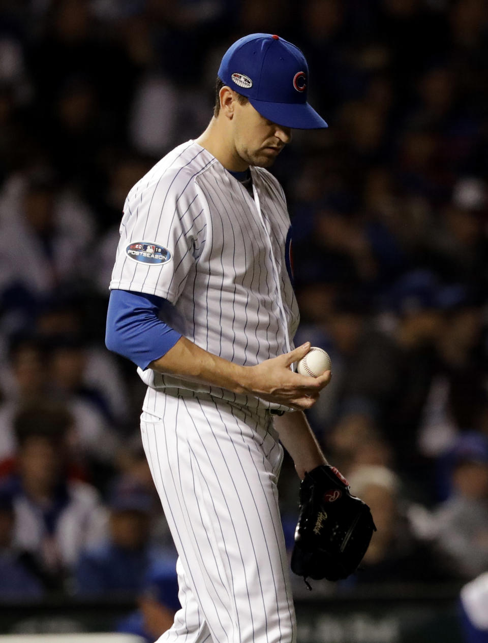 Chicago Cubs relief pitcher Kyle Hendricks looks down as he checks the ball after Colorado Rockies' Gerardo Parra hit a single during the 13th inning of the National League wild-card playoff baseball game Tuesday, Oct. 2, 2018, in Chicago. (AP Photo/Nam Y. Huh)