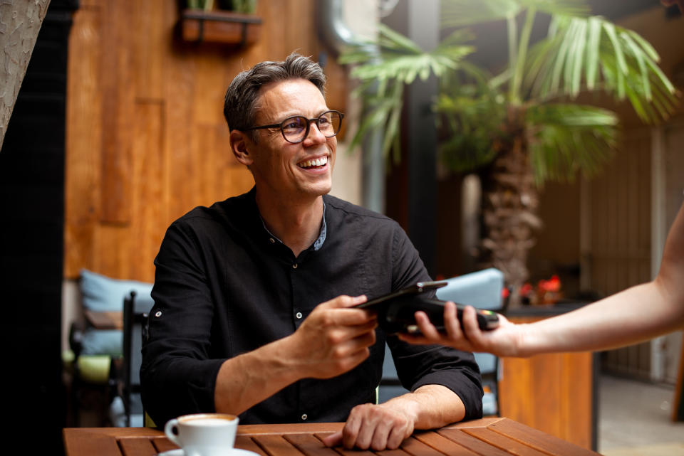 person pays with a credit card at a restaurant using a mobile pos system