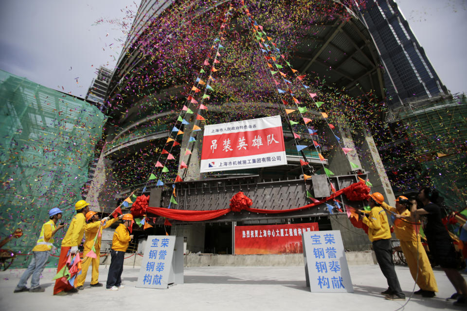 The last piece of the tower is lifted to put in place at the top of the Shanghai Tower during the topping off ceremony in Shanghai, China, Saturday, Aug. 3, 2013. The Shanghai Tower is set to become the tallest building in China which is planned to be complete in 2014. (AP Photo/Eugene Hoshiko)