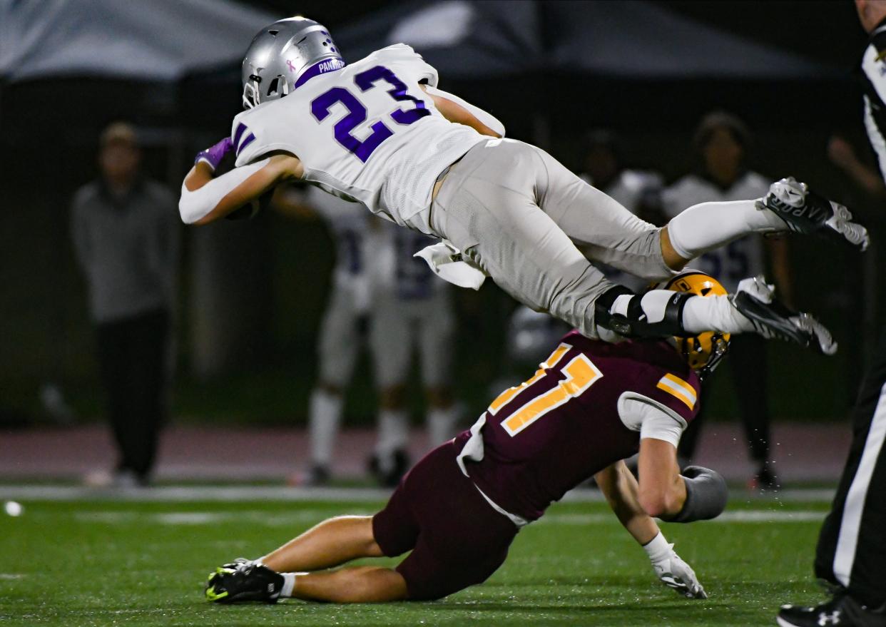 Bloomington South’s Ben Morrison (23) goes airborne after a tackle by Bloomington North’s Graham Freund (17) during the IHSAA sectional semi-final football game at Bloomington North on Friday, Oct. 27, 2023.