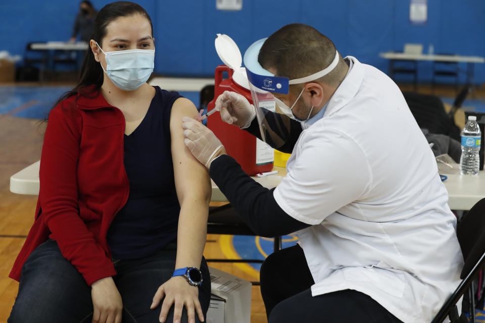 A Peter Cooper Public School teacher receives the Moderna coronavirus vaccine from a Walgreens pharmacist at Roberto Clemente Community Academy of Chicago on Feb. 11, 2021. (Photo: AP Photo/Shafkat Anowar)