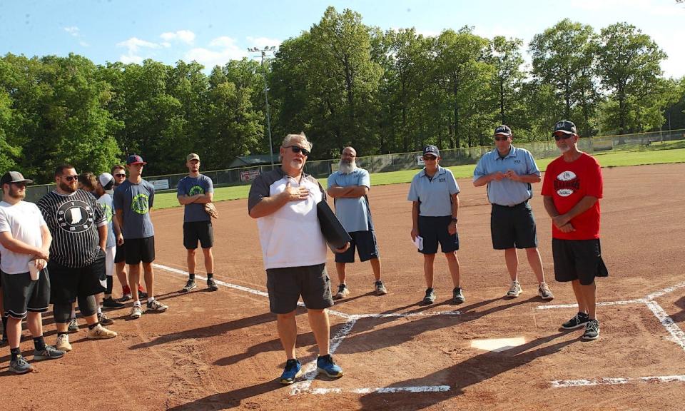 Bedford Parks Department director Gary Dorsett pays tribute to Ralph "Froggy" Poole (right), who has retired after 39 years as a softball umpire at Otis and Murray Parks.