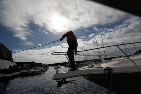 A man reinforces with ropes the mooring of his boat at a port before the arrival of Hurricane Lorenzo in Angra do Heroismo in the Azores islands