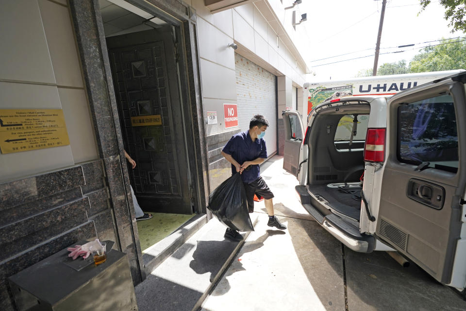 A man loads the back of a van with a bag from inside the Chinese Consulate Thursday, July 23, 2020, in Houston. China says “malicious slander" is behind an order by the U.S. government to close its consulate in Houston, and maintains that its officials have never operated outside ordinary diplomatic norms. (AP Photo/David J. Phillip)