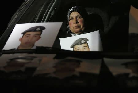 Mother of Islamic State captive Jordanian pilot Muath al-Kasaesbeh holds his picture while sitting in a car, as she takes part in a demonstration demanding that the Jordanian government negotiate with Islamic state and for the release of her son, in front of the prime minister's building in Amman, January 27, 2015. REUTERS/Muhammad Hamed