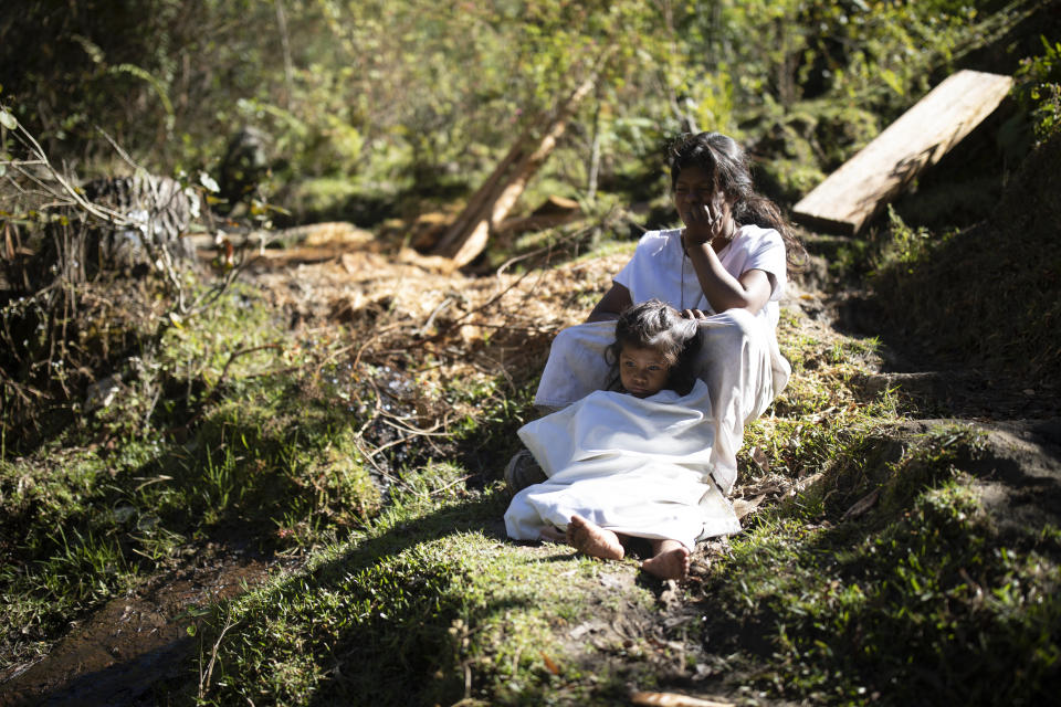 Arhauco Indigenous girls sit by a ravine in Nabusimake on the Sierra Nevada de Santa Marta, Colombia, Tuesday, Jan. 17, 2023. The Arhuaco are an Indigenous people of Colombia, descendants of the Tairona culture, concentrated in northern Colombia in the Sierra Nevada de Santa Marta. (AP Photo/Ivan Valencia)