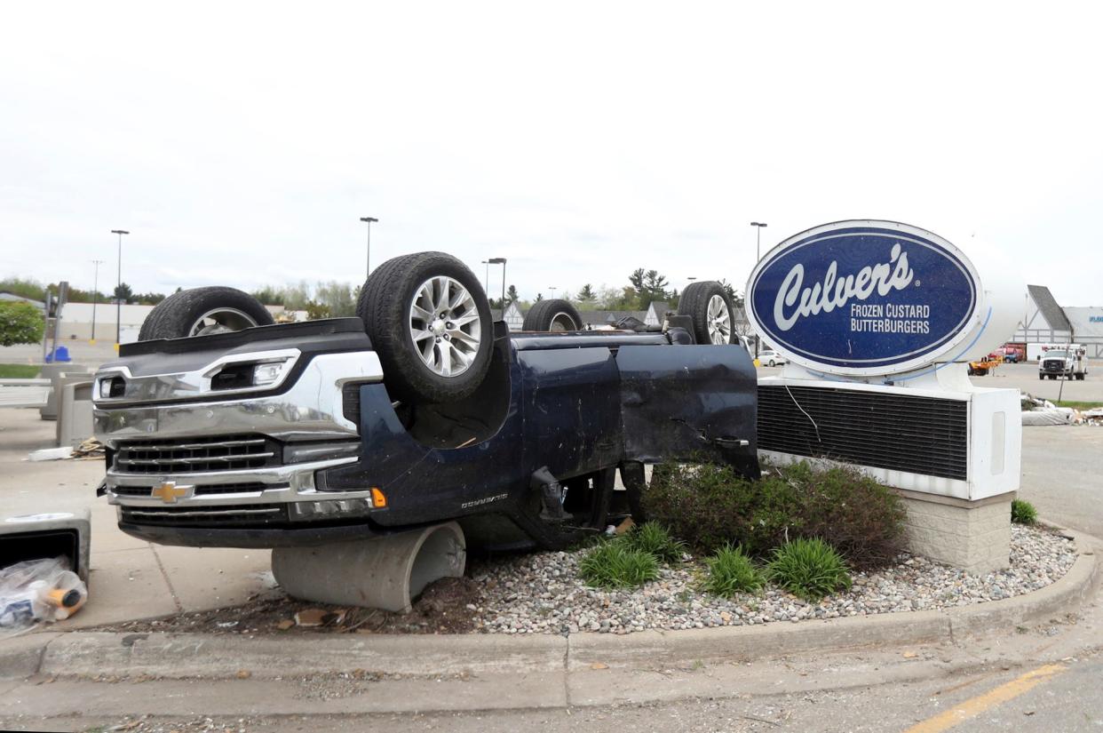 An overturned car is seen near the sign for Culver's restaurant along West M-32 in Gaylord following the May 20, 2022 tornado.
