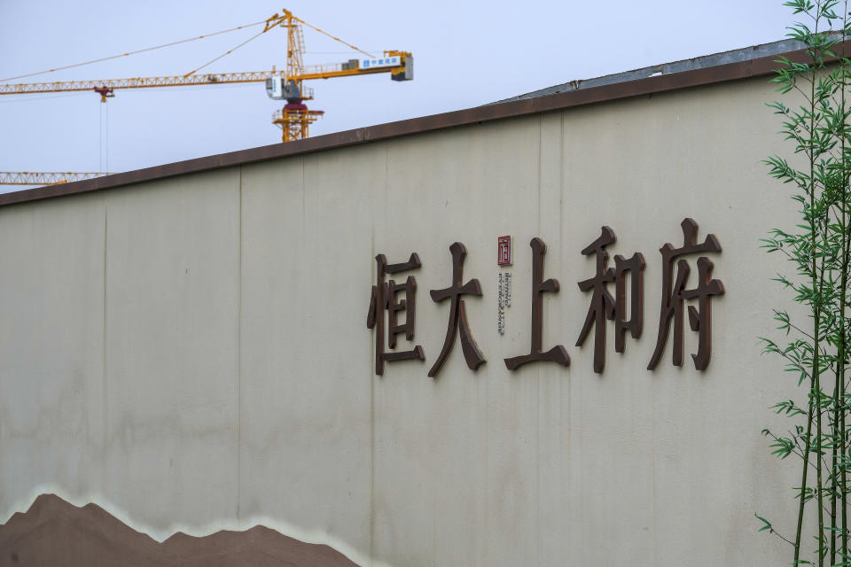 A construction crane stands on a new housing development project by Evergrande in Beijing, Wednesday, Sept. 15, 2021. One of China's biggest real estate developers is struggling to avoid defaulting on billions of dollars of debt, prompting concern about the broader economic impact and protests by apartment buyers about delays in completing projects. Rating agencies say Evergrande Group appears likely to be unable to repay all of the 572 billion yuan ($89 billion) it owes banks and other bondholders. That might jolt financial markets, but analysts say Beijing is likely to step in to prevent wider damage. (AP Photo/Andy Wong)