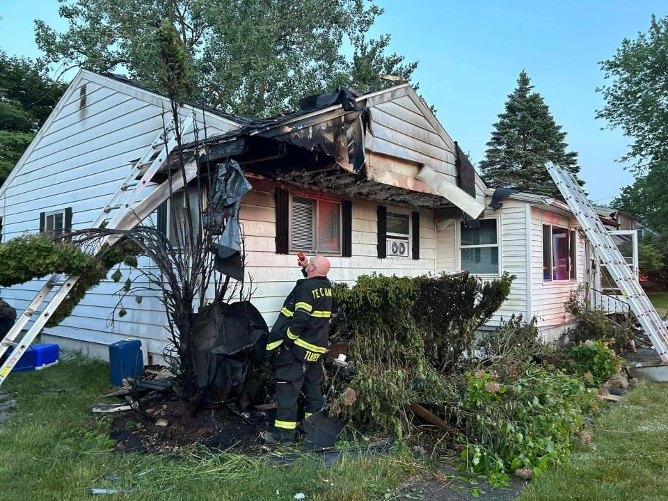 Tecumseh Fire Chief Joe Tuckey examines the damage caused by a fire Thursday evening to this house on Cairns Street.