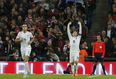 England captain Wayne Rooney (C) celebrates after scoring from a penalty kick during their Euro 2016 Group E qualifying soccer match against Slovenia at Wembley Stadium in London November 15, 2014. REUTERS/Suzanne Plunkett