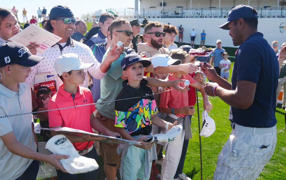 Feb 8, 2022; Scottsdale, Arizona, USA; Tony Finau signs autographs for fans during a practice round at the Waste Management Phoenix Open on Tuesday. Mandatory Credit: Patrick Breen-The Republic