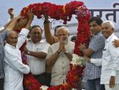 Hindu nationalist Narendra Modi, the prime ministerial candidate for India's main opposition Bharatiya Janata Party (BJP), gestures as he receives a garland from his supporters during a public meeting in Vadodara, in the western Indian state of Gujarat, May 16, 2014. REUTERS/Amit Dave