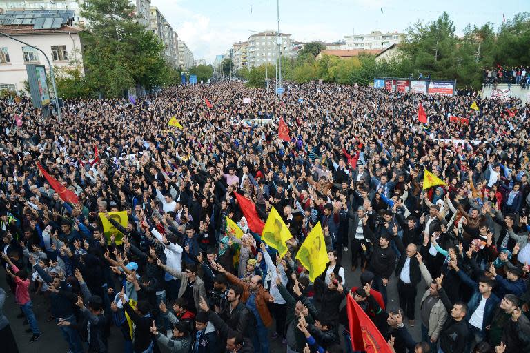 Kurds flash the "V" for victory sign as they gather on November 1, 2014 in Diyarbakir, southeastern Turkey, during a rally in support of the Syrian city of Kobane