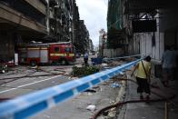 <p>A fireman (C) is seen next to a fire truck in a cordoned off residential area in Macau on Aug.24, 2017, a day after Typhoon Hato hit the city. (Photo: Anthony Wallace/AFP/Getty Images) </p>