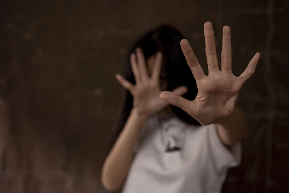 Woman with hands raised in defence