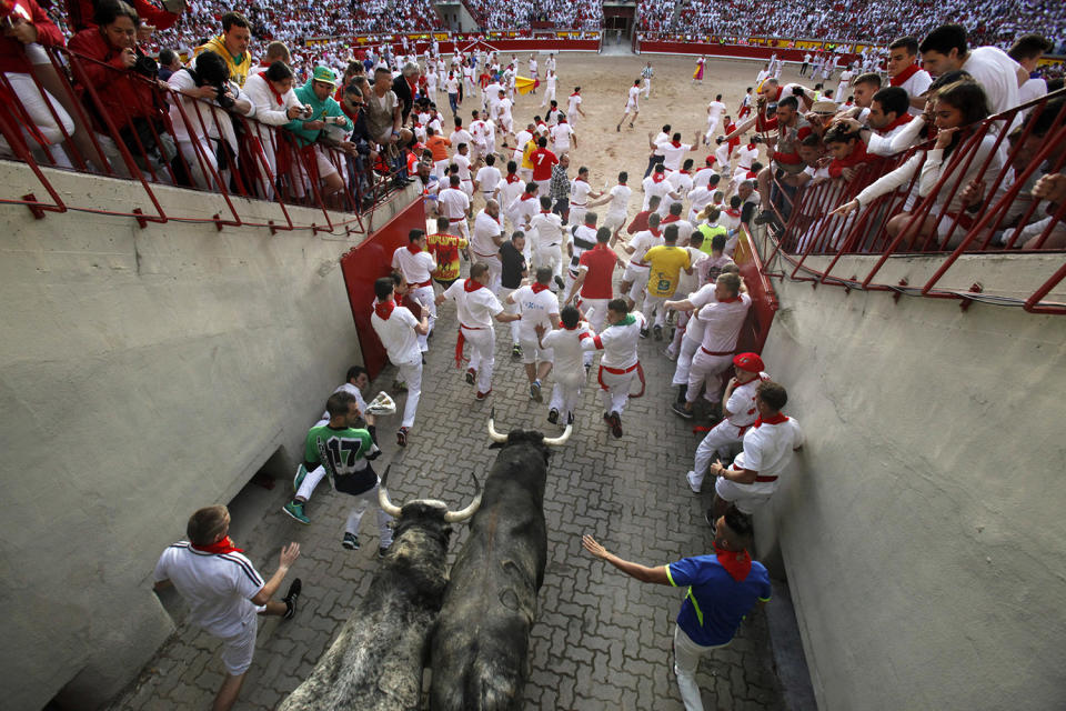 <p>Revellers run with Cebada Gago’s fighting bulls entering the bullring during the second day of the San Fermin Running of the Bulls festival on July 7, 2017 in Pamplona, Spain. (Pablo Blazquez Dominguez/Getty Images) </p>