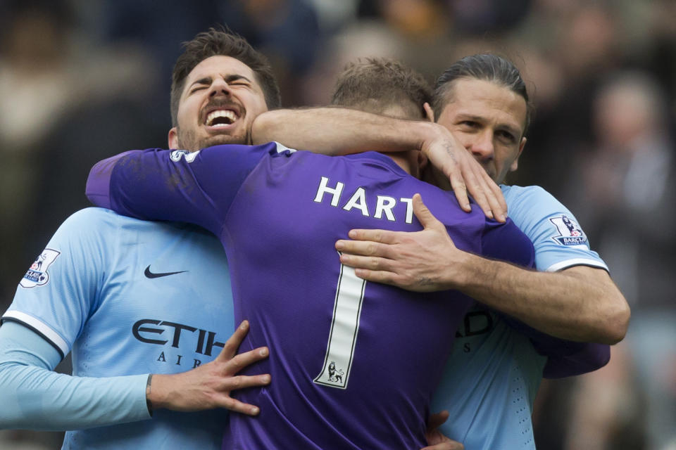 Manchester City's Javier Garcia, left, and Martin Demichelis, right, celebrate with goalkeeper Joe Hart after their 2-0 win against Hull City in their English Premier League soccer match at the KC Stadium, Hull, England, Saturday March 15, 2014. (AP Photo/Jon Super)