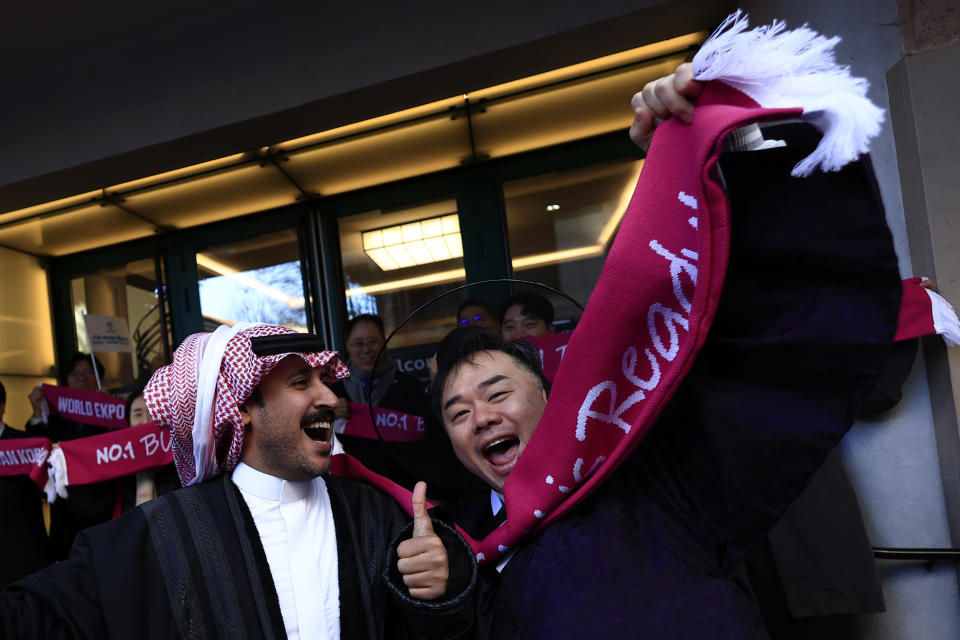 A supporter of the candidacy of Busan, South Korea, jokes with a supporter Riyadh , Saudi Arabia, Tuesday, Nov. 28, 2023 in Issy-les-Moulineaux, outside Paris. In a high-profile showdown, Rome, Busan, and Riyadh are the top contenders as the Bureau International des Expositions (BIE) prepares to vote on Tuesday in Paris for the host city of the 2030 World Expo. (AP Photo/Aurelien Morissard)