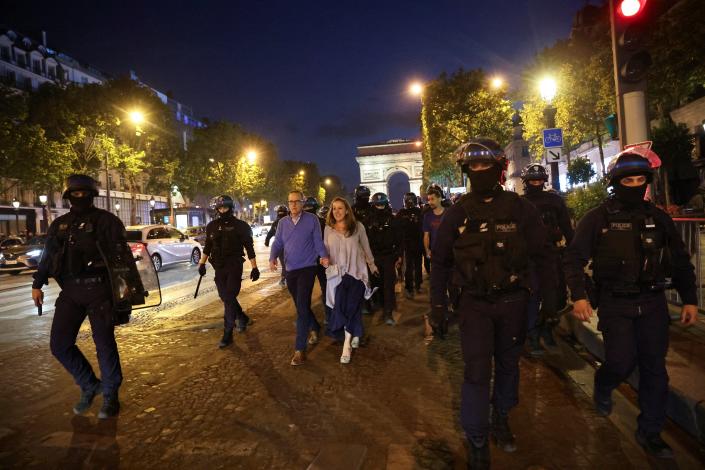 Police officers walk with people through the streets of Paris (REUTERS)