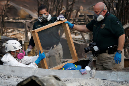 Forensic anthropologist Kyra Stull (L) and staff from the Marin County Coroner Division sift human remains from a trailer home destroyed by the Camp Fire in Paradise, California, U.S., November 17, 2018. REUTERS/Terray Sylvester