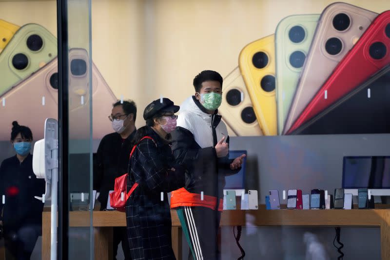 People wearing protective masks are seen in an Apple Store, as China is hit by an outbreak of the new coronavirus, in Shanghai