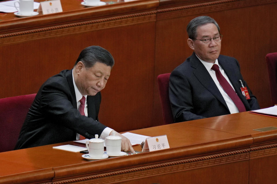 Chinese President Xi Jinping, left, press a button to vote as Premier Li Qiang looks on during the closing session of the National People's Congress (NPC) at the Great Hall of the People in Beijing, Monday, March 11, 2024. (AP Photo/Andy Wong)