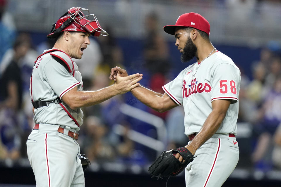 Philadelphia Phillies catcher J.t. Realmuto, and relief pitcher Seranthony Dominguez (58) celebrate after the team's baseball game against the Miami Marlins, Friday, July 15, 2022, in Miami. The Phillies won 2-1. (AP Photo/Lynne Sladky)