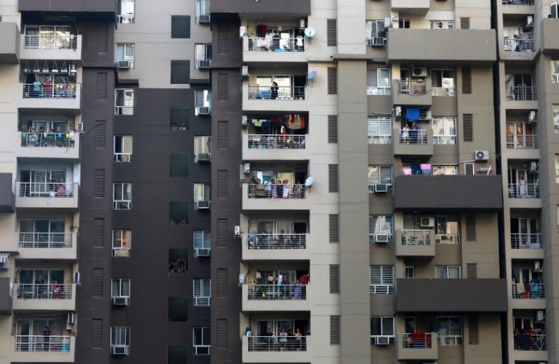 Residents clap and bang utensils from their balconies to cheer for emergency personnel and sanitation workers who are on the frontlines in the fight against coronavirus, in Noida