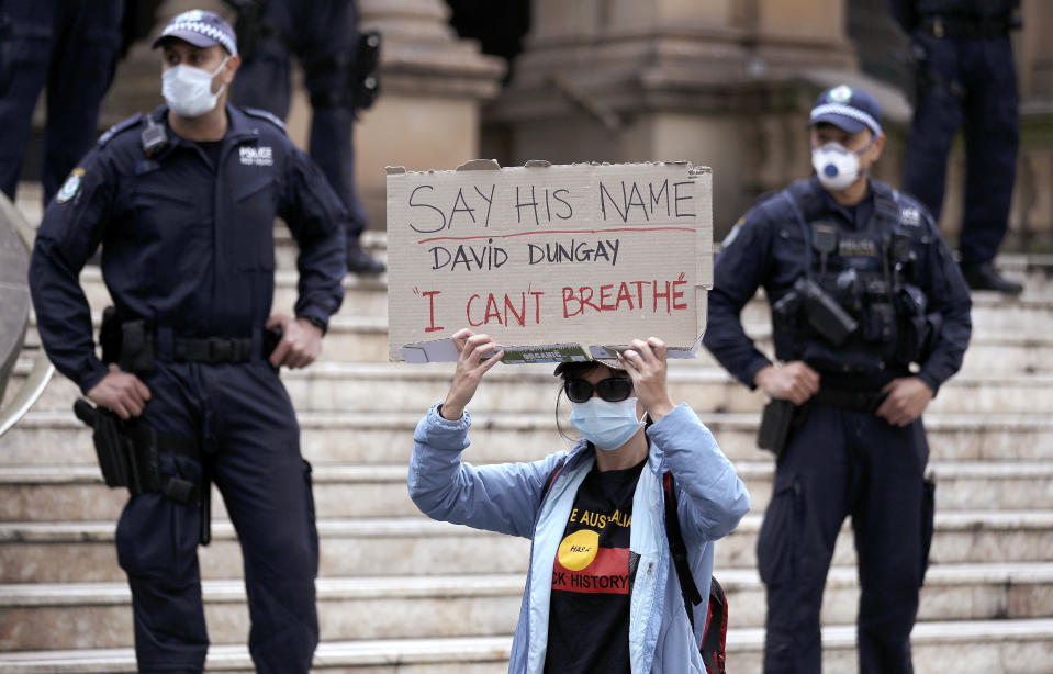 Una mujer sostiene un cartel durante una movilización del movimiento Black Lives Matter en Sydney, Australia, el 13 de junio de 2020. (AP Foto/Rick Rycroft)