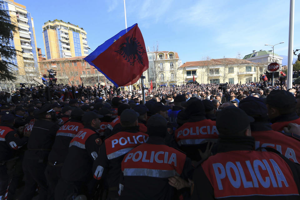 Police officer stand and block the protesters during an anti-government rally in Tirana, Albania, Thursday, March 21, 2019. Thousand opposition protesters have gathered in front of Albania's parliament building calling for the government's resignation and an early election. Rally is part of the center-right Democratic Party-led opposition's protests over the last month accusing the leftist Socialist Party government of Prime Minister Edi Rama of being corrupt and linked to organized crime. (AP Photo/ Hektor Pustina)