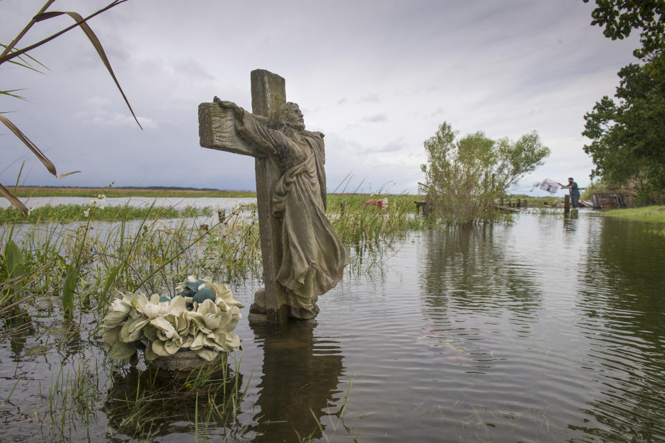 Casey Guidry, 22, far right, moves crab traps that had been pushed around from the rising water near his home along Salt Bayou near Slidell on Tuesday, September 15, 2020. Hurricane Sally missed Louisiana, but its effect, such as high water, could be felt along the region. (Chris Granger/The Advocate via AP)