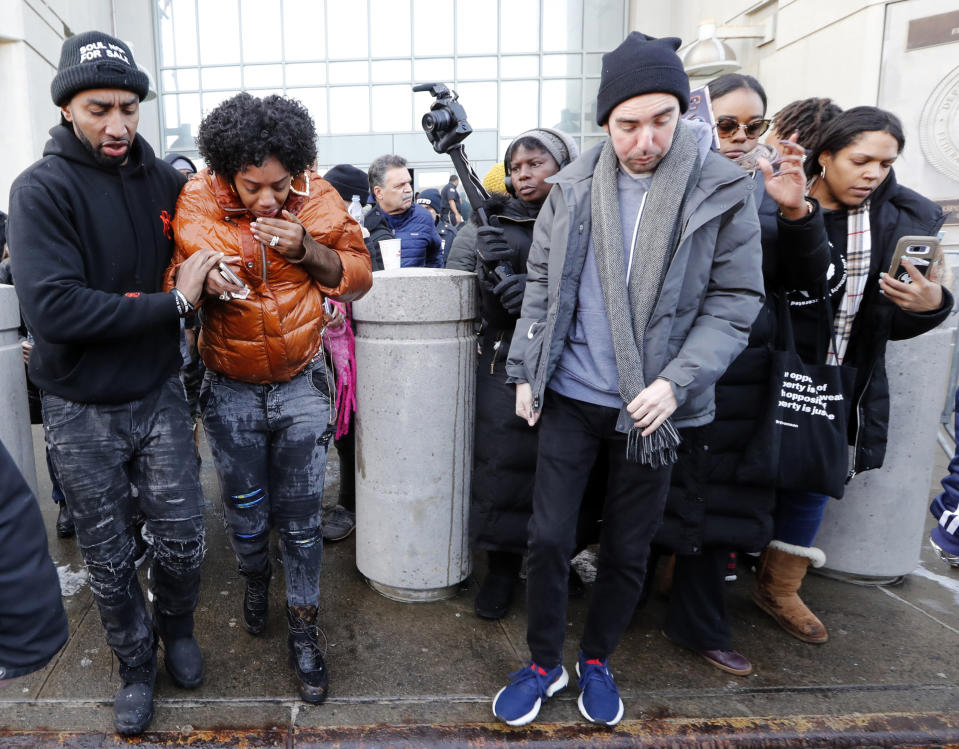 Yandy Smith, second from left, is helped by others after she joined protesters and prisoners' family members in storming the main entrance of the Metropolitan Detention Center, Sunday, Feb. 3, 2019, in the Brooklyn borough of New York, in protest of conditions at the facility. The federal prison has been without heat, hot water, electricity and sanitation since mid-week, including throughout the recent frigid weather. (AP Photo/Kathy Willens)