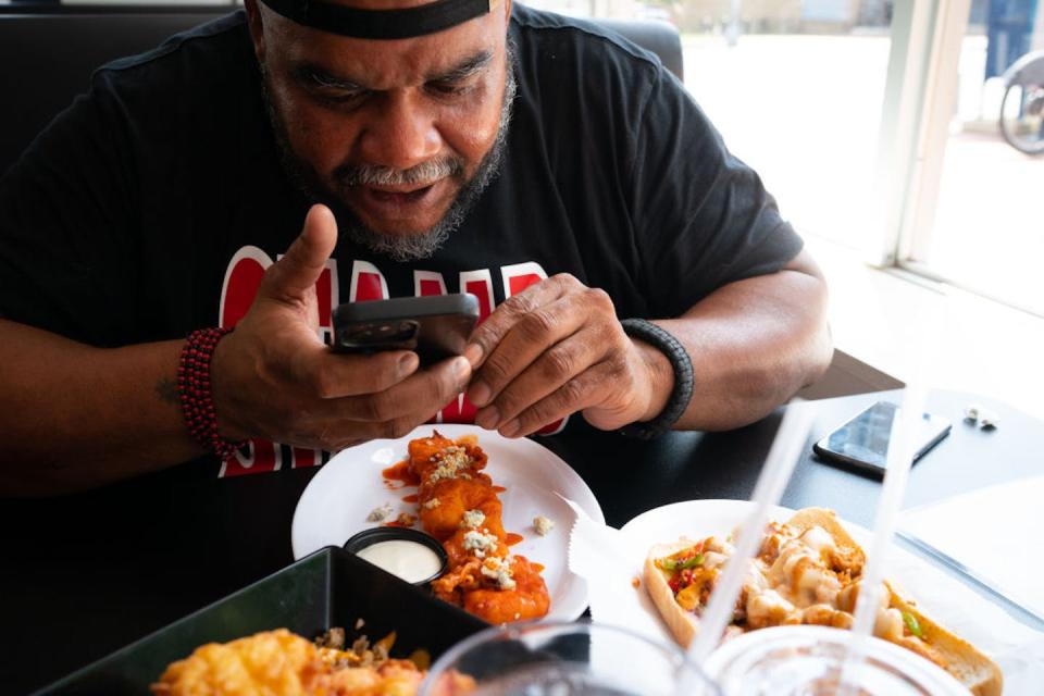 Food influencer Larry Mcleod, 47, better known on social media as Big Schlim, reviews the restaurant Shellfish Market in Washington, D.C. <a href="https://www.gettyimages.com/detail/news-photo/washington-dc-larry-mcleod-of-greenbelt-better-known-on-news-photo/1718277220?adppopup=true" rel="nofollow noopener" target="_blank" data-ylk="slk:Sarah L. Voisin/The Washington Post via Getty Images;elm:context_link;itc:0;sec:content-canvas" class="link ">Sarah L. Voisin/The Washington Post via Getty Images</a>