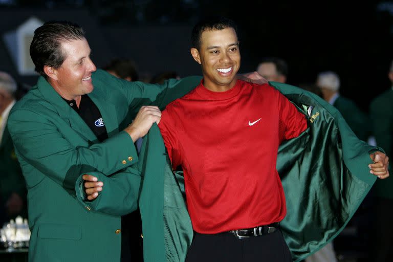 Tiger Woods recibe la chaqueta verde del ex campeón Phil Mickelson después de que Woods ganó el torneo Masters 2005 en el primer hoyo de un desempate de muerte súbita sobre Chris DiMarco, en el Augusta National Golf Club en Augusta, Georgia, 10 de abril de 2005.