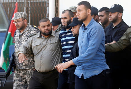 Members of Palestinian security forces loyal to Hamas escort an alleged collaborator with Israel (C), who was convicted in killing senior Hamas commander Mazen Fuqaha, as he leaves a Hamas-run military court in Gaza City May 21, 2017. REUTERS/Mohammed Salem