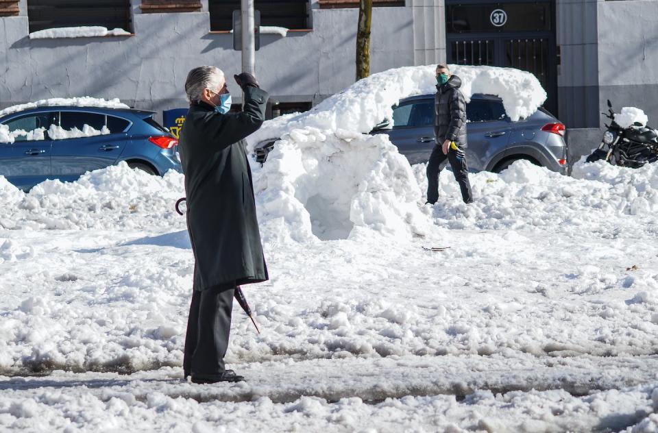 Un hombre con mascarilla observa los efectos de la tormenta Filomena en Madrid en enero de 2021. <a href="https://www.shutterstock.com/es/image-photo/madrid-spain-01-10-2021-effect-1891281811" rel="nofollow noopener" target="_blank" data-ylk="slk:Shutterstock / Alex Castellon;elm:context_link;itc:0;sec:content-canvas" class="link ">Shutterstock / Alex Castellon</a>