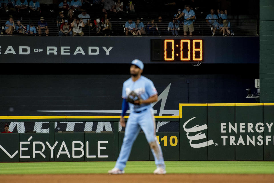 FILE - The pitch clock ticks down in the top of the ninth in a baseball game between the Texas Rangers and Philadelphia Phillies in Arlington, Texas, Sunday, April 2, 2023. Major League Baseball's pitch clock has made games go faster, but players and coaches believe it also is leading to better fielding. The pitch clock, an idea meant to make it easier for fans to stay focused on the field — may be keeping fielders locked in, too. (AP Photo/Emil T. Lippe, File)