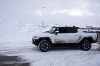 A General Motors' Hummer EV vehicle drives by a mound of snow at a charging station, Wednesday, Feb. 22, 2023, in Sault Ste. Marie, Mich. Some automakers and drivers fear lower battery range in the cold could limit acceptance of electric cars, trucks and buses, at a time when emissions from transportation must go down sharply to address climate change. General Motors is among those working on solutions. (AP Photo/Carlos Osorio)